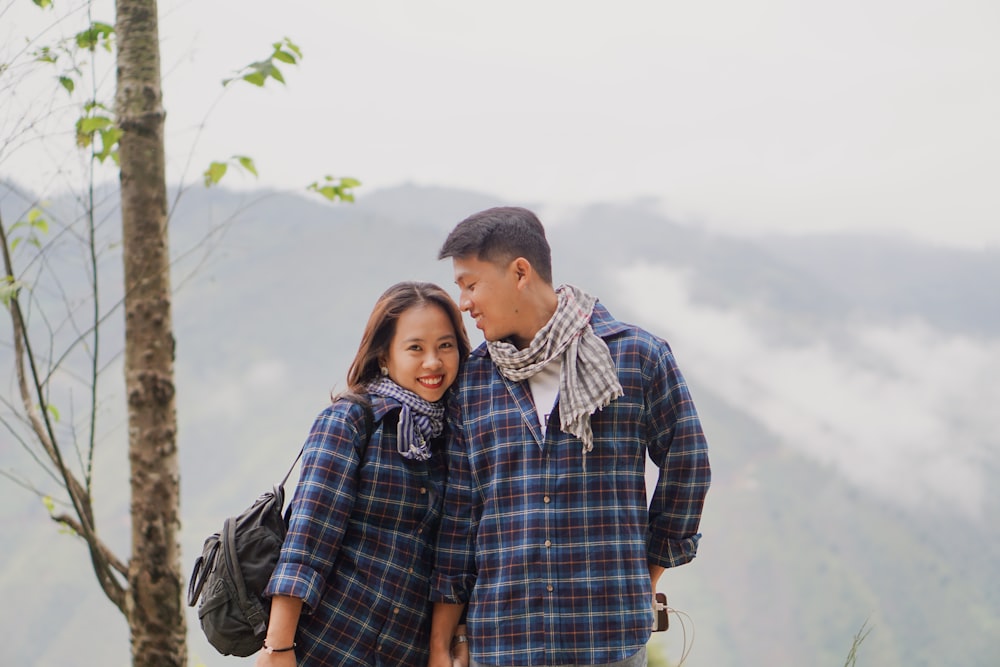 man in blue and white plaid dress shirt hugging woman in blue and white plaid dress