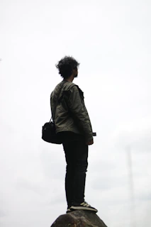 man in gray jacket standing on white snow covered ground during daytime