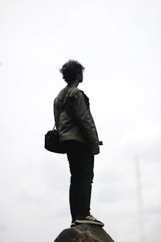 man in gray jacket standing on white snow covered ground during daytime