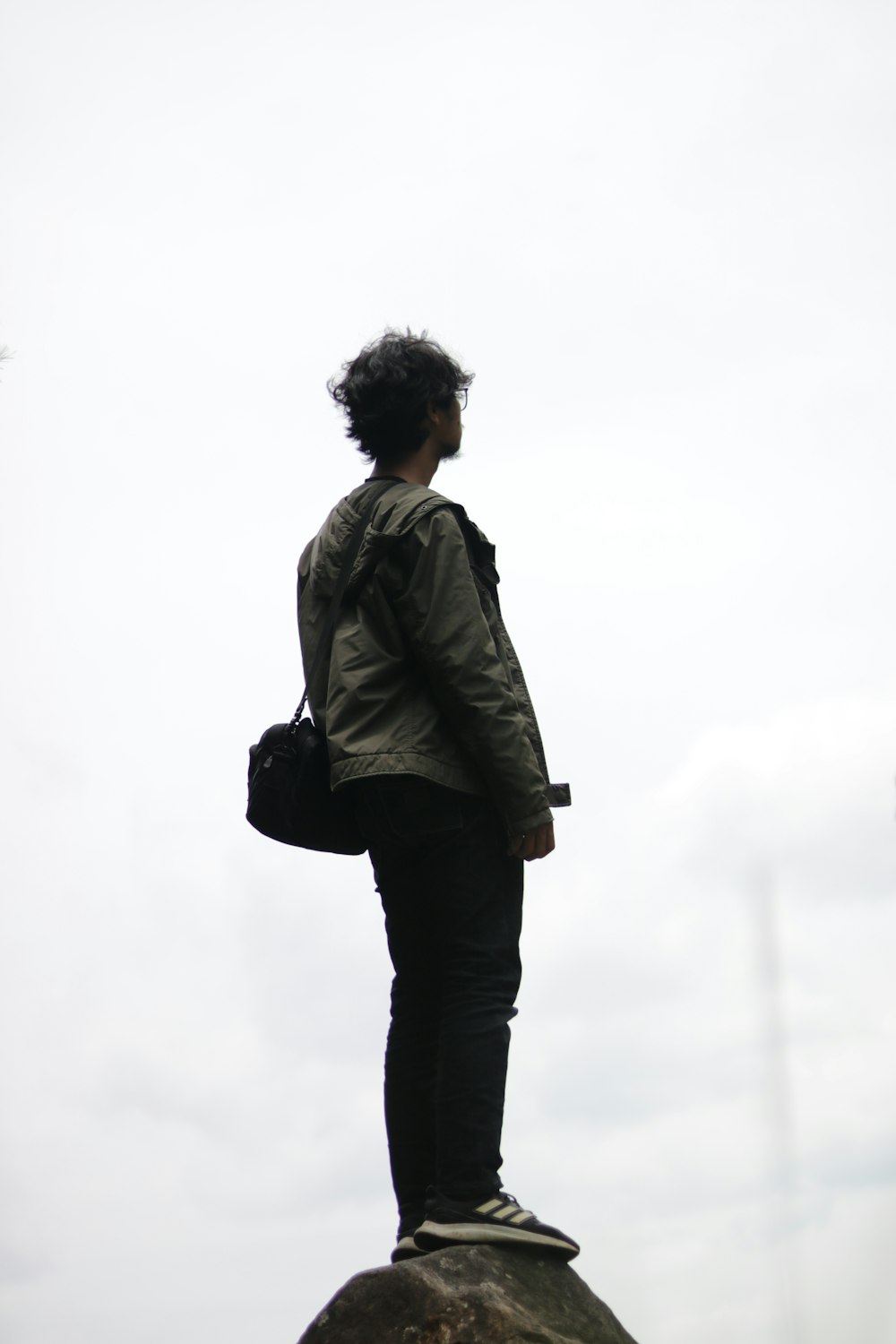 man in gray jacket standing on white snow covered ground during daytime