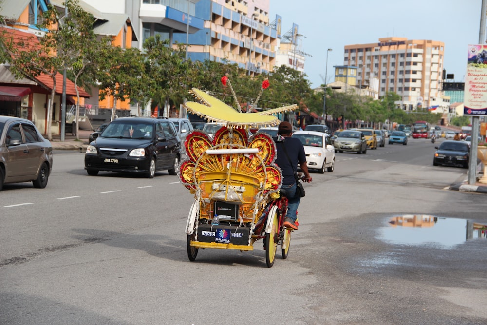 people riding on red and yellow trike on road during daytime