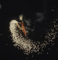 person in red jacket and blue denim jeans standing on white snow covered ground during night