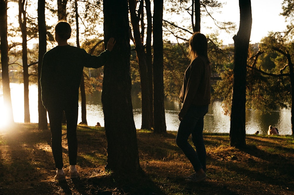 man and woman standing in forest during daytime