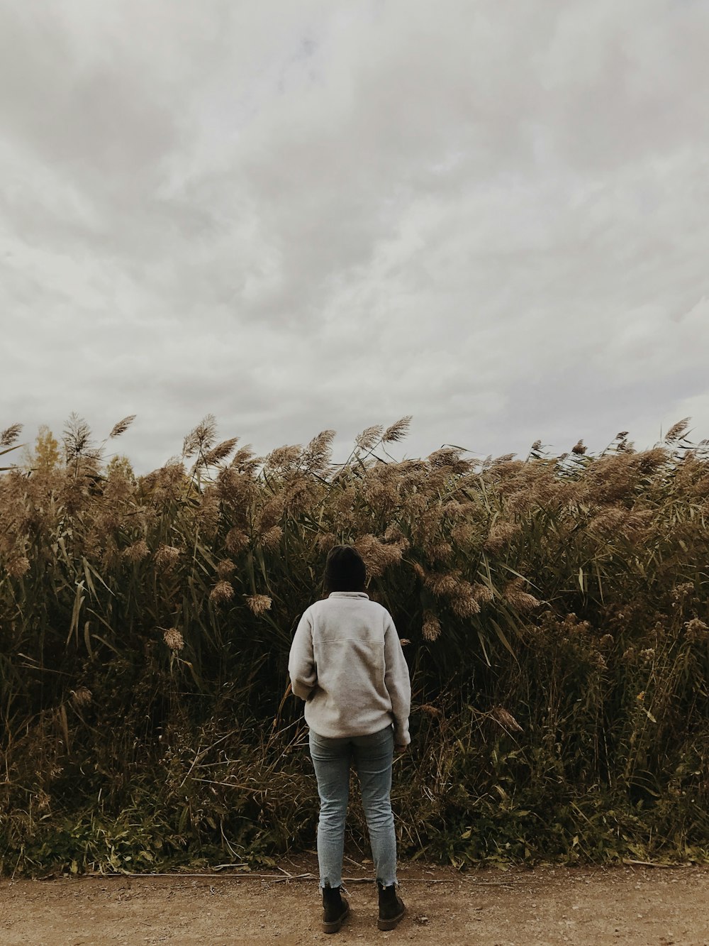 man in white long sleeve shirt standing on brown grass field during daytime