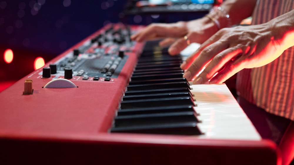 person playing red and black piano