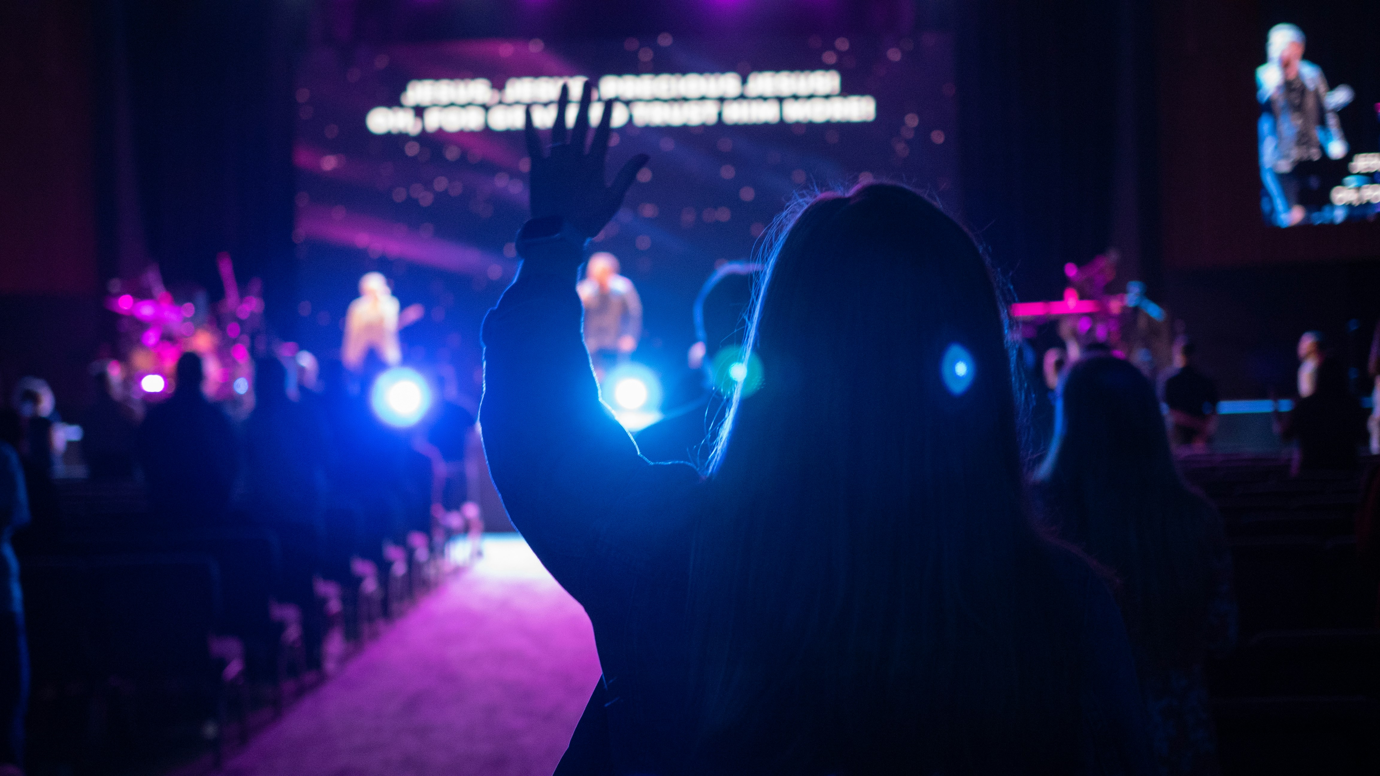 man in black suit raising his hands