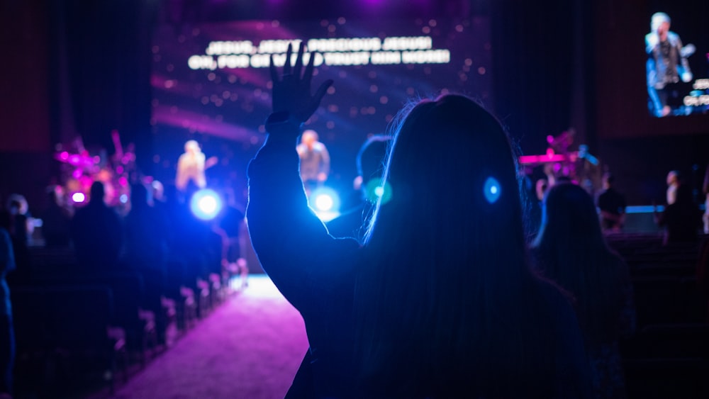 man in black suit raising his hands