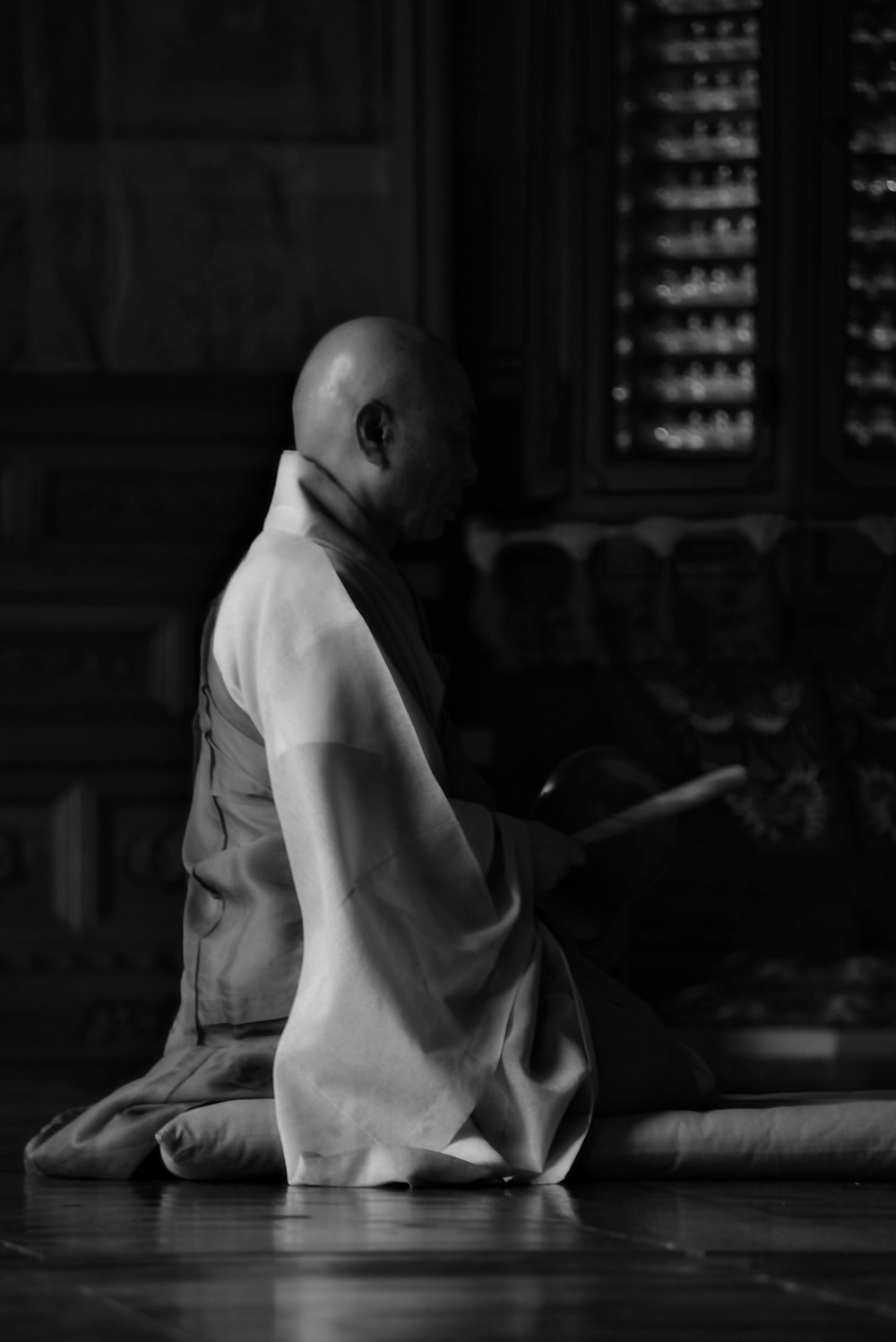 man in white robe holding stick