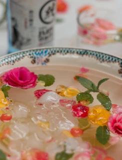 Artfully arranged cocktail garnishes made from freeze-dried flowers and fruits on a dark plate