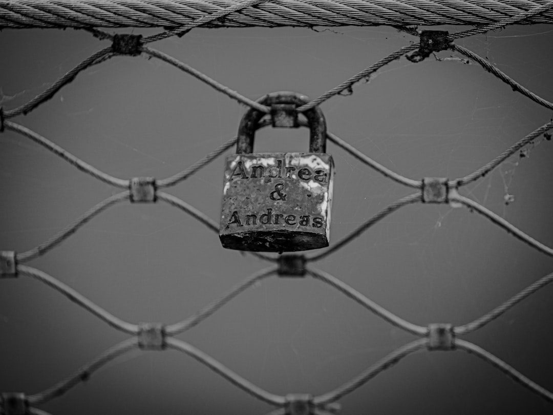 padlock on wire in grayscale photography