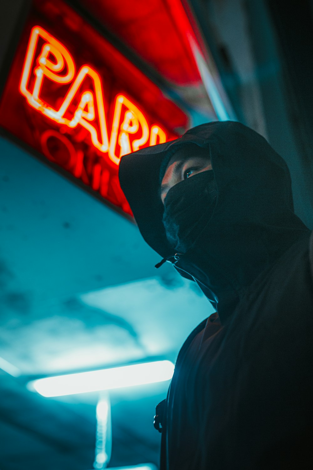 Mann in schwarzem Kapuzenpullover mit schwarzer Maske