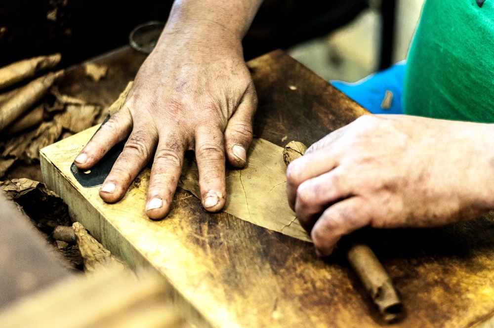 person holding brown wooden chopping board