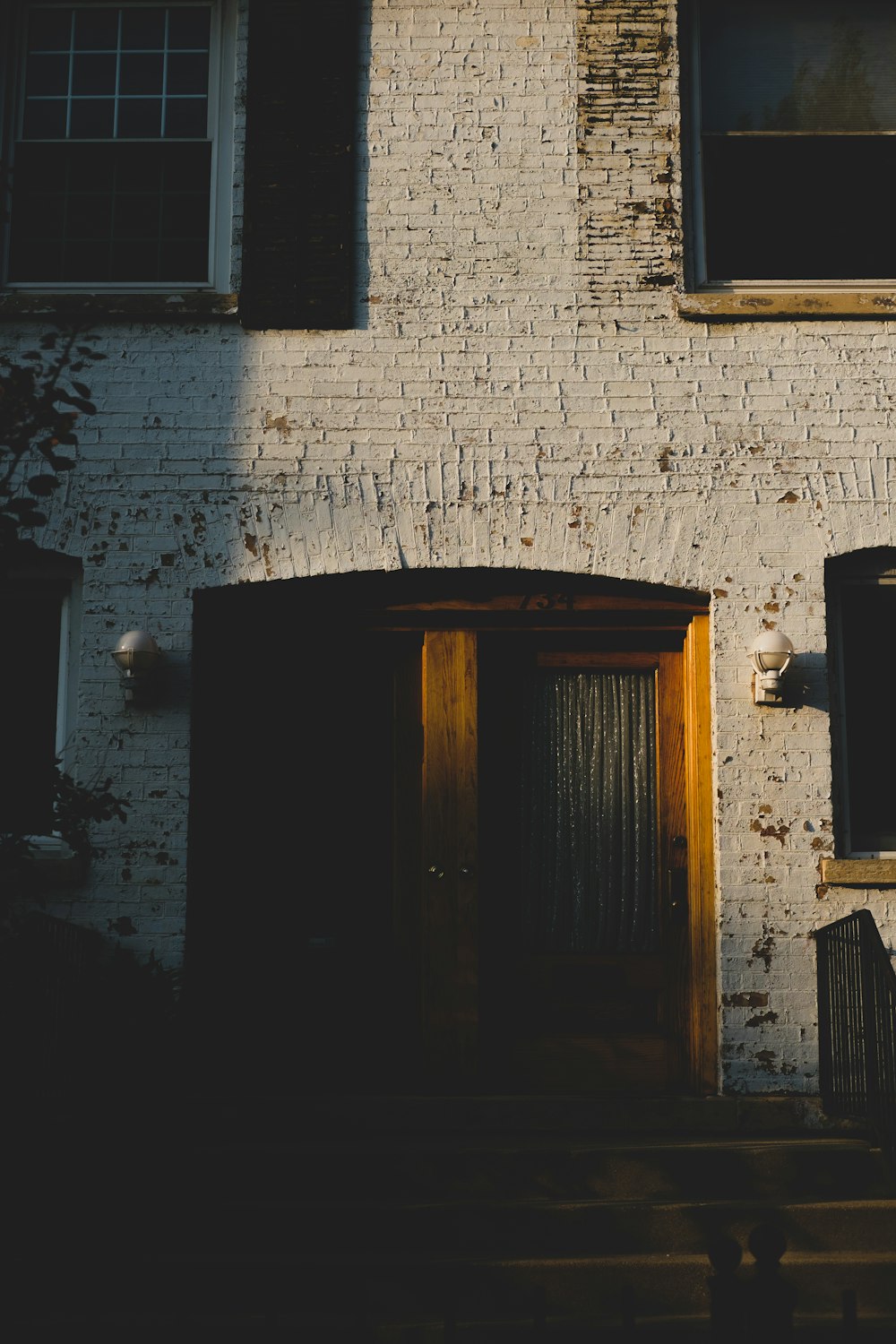 brown wooden cabinet beside white brick wall