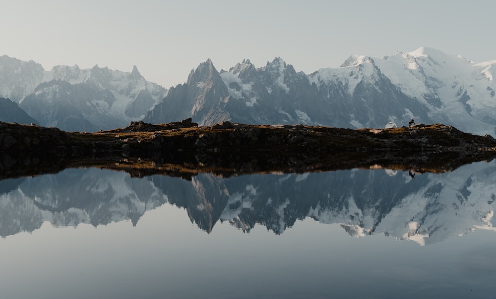 snow covered mountain near lake during daytime