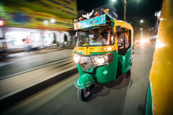 Passengers boarding a sleek battery-operated e-rickshaw on a sunny morning.