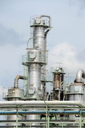 white and brown factory under blue sky during daytime