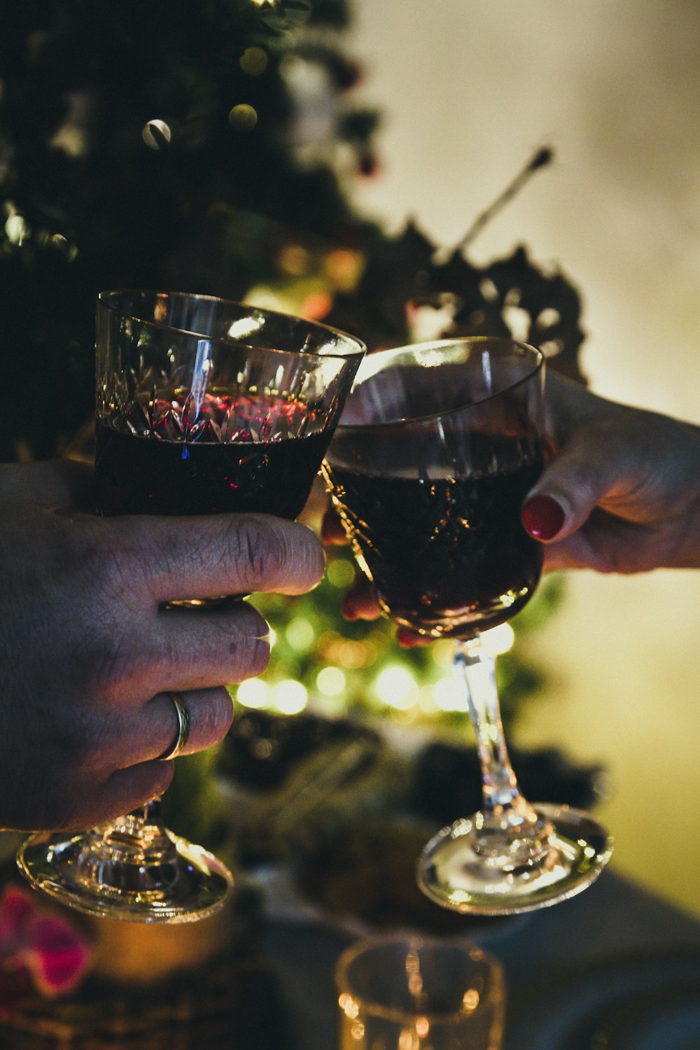 person holding clear wine glass with red wine