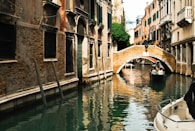 white boat on river between concrete buildings during daytime