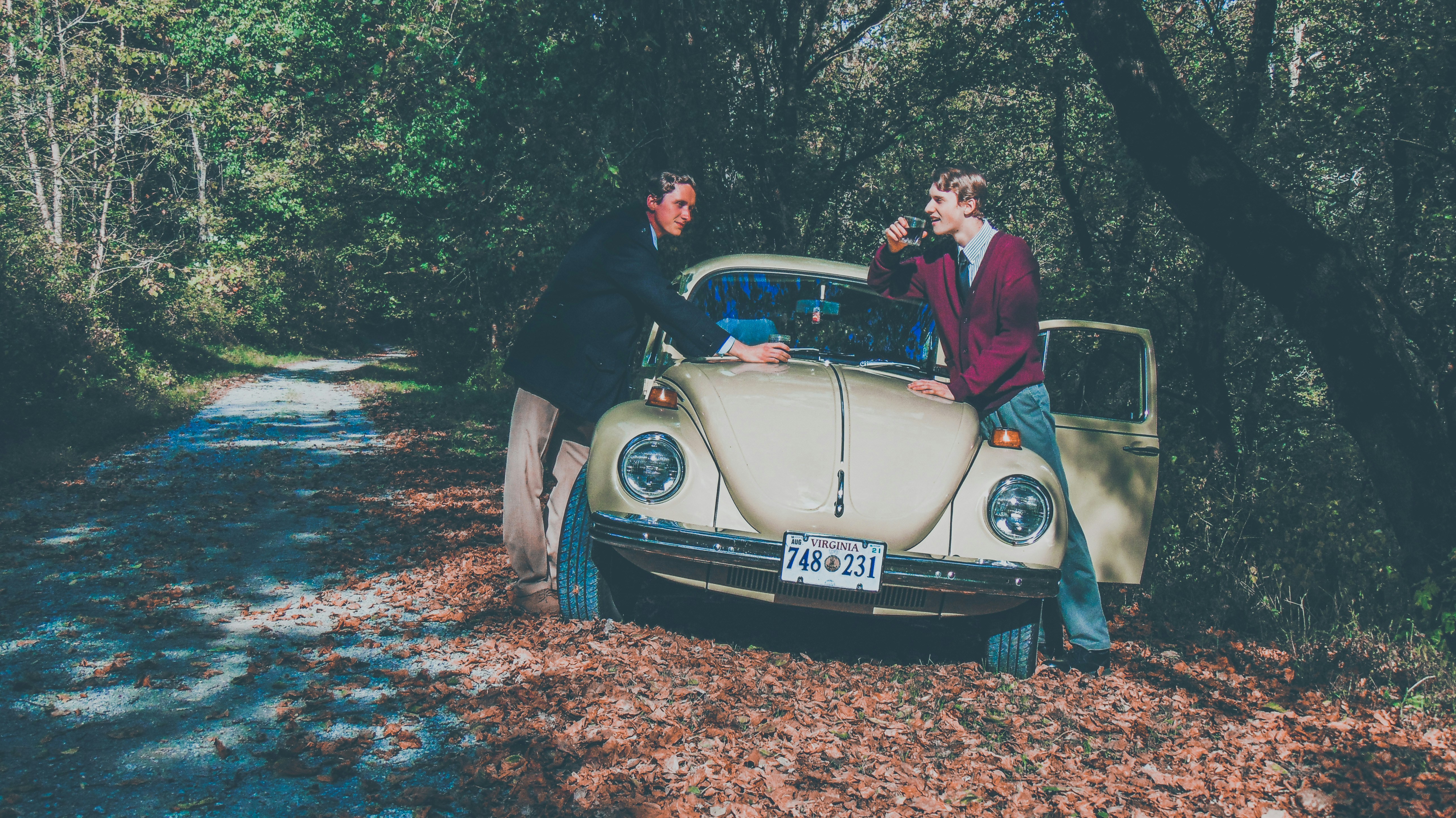 man in black t-shirt and black shorts sitting on beige convertible car