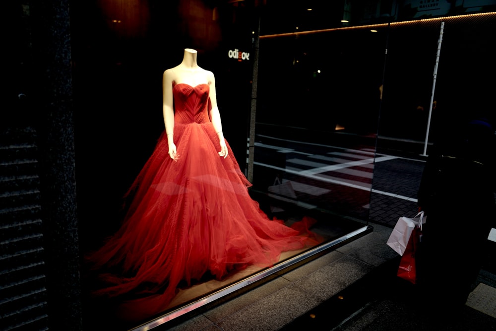 donna in vestito rosso in piedi sul pavimento nero