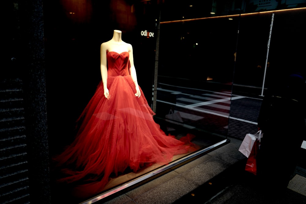 mujer con vestido rojo de pie en el suelo negro