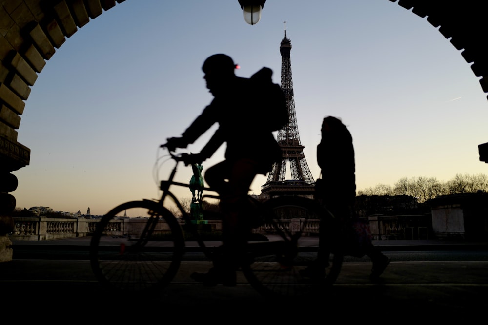 silhouette of man riding bicycle during sunset