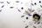 A playful arrangement of Halloween-themed decorations including felt crafts of a ghost and a black cat, surrounded by various sizes of googly eyes, small bats with cartoonish features, sparkly purple bat cutouts, and flat skull shapes on a light background.