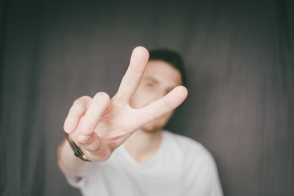 person in white long sleeve shirt wearing silver ring