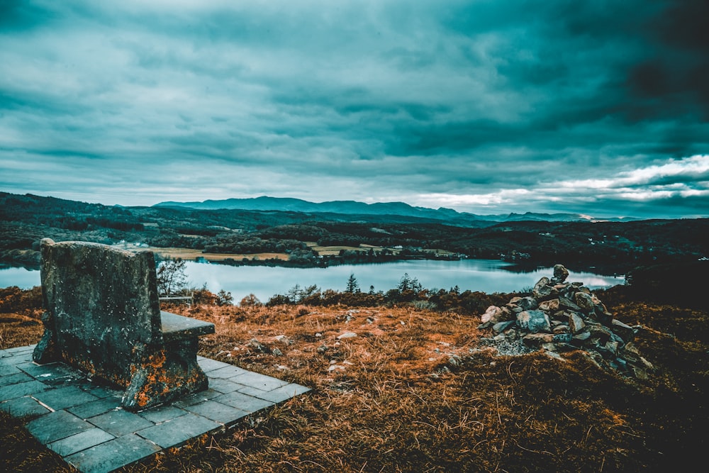 brown wooden dock on body of water under cloudy sky during daytime