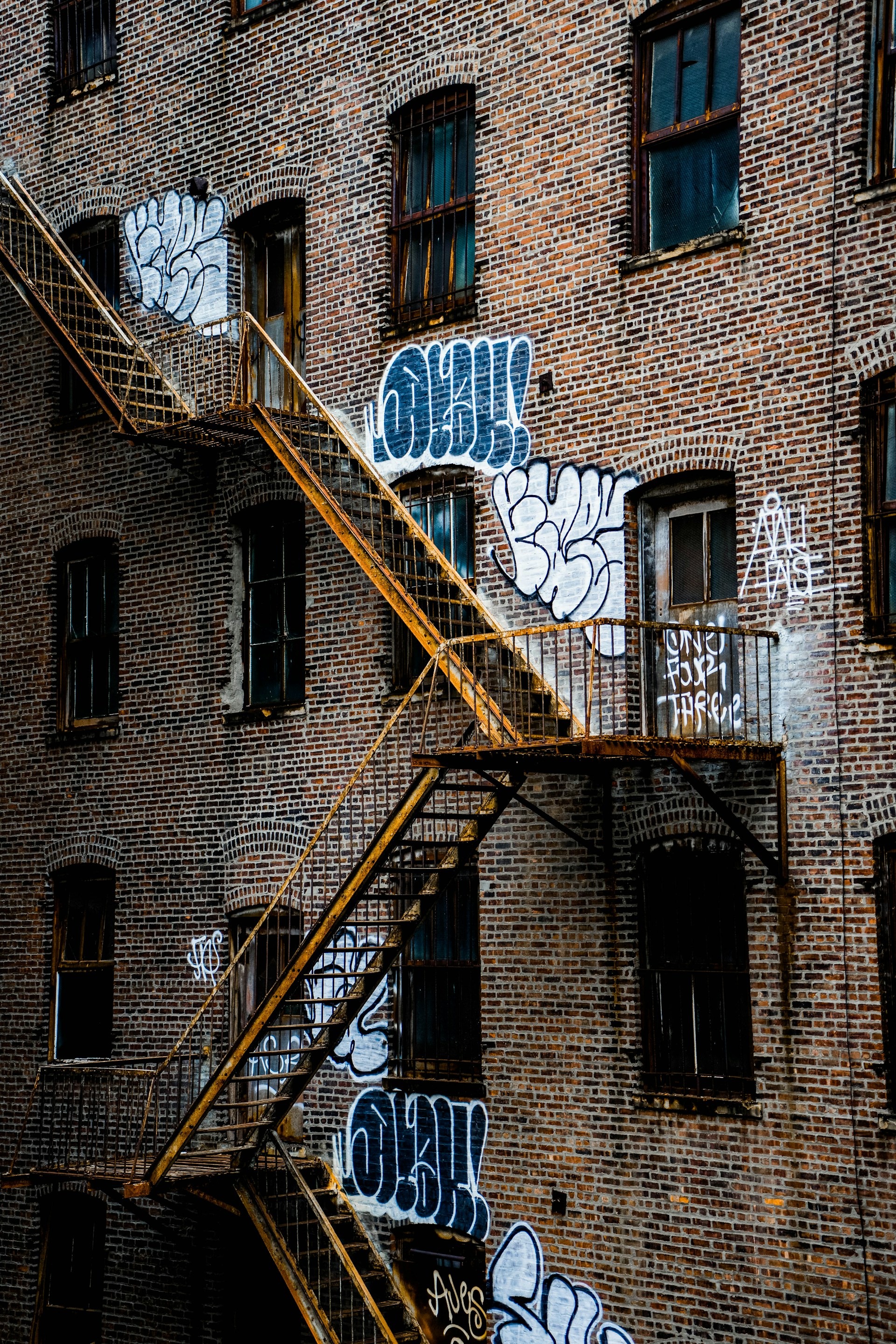 brown brick building with yellow metal ladder