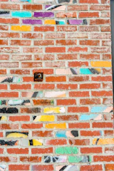 An outdoor brick wall with a colorful UV printed design shining under sunlight