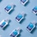 Several small bottles of hand sanitizer with blue labels are arranged on a light blue background in a diagonal pattern.