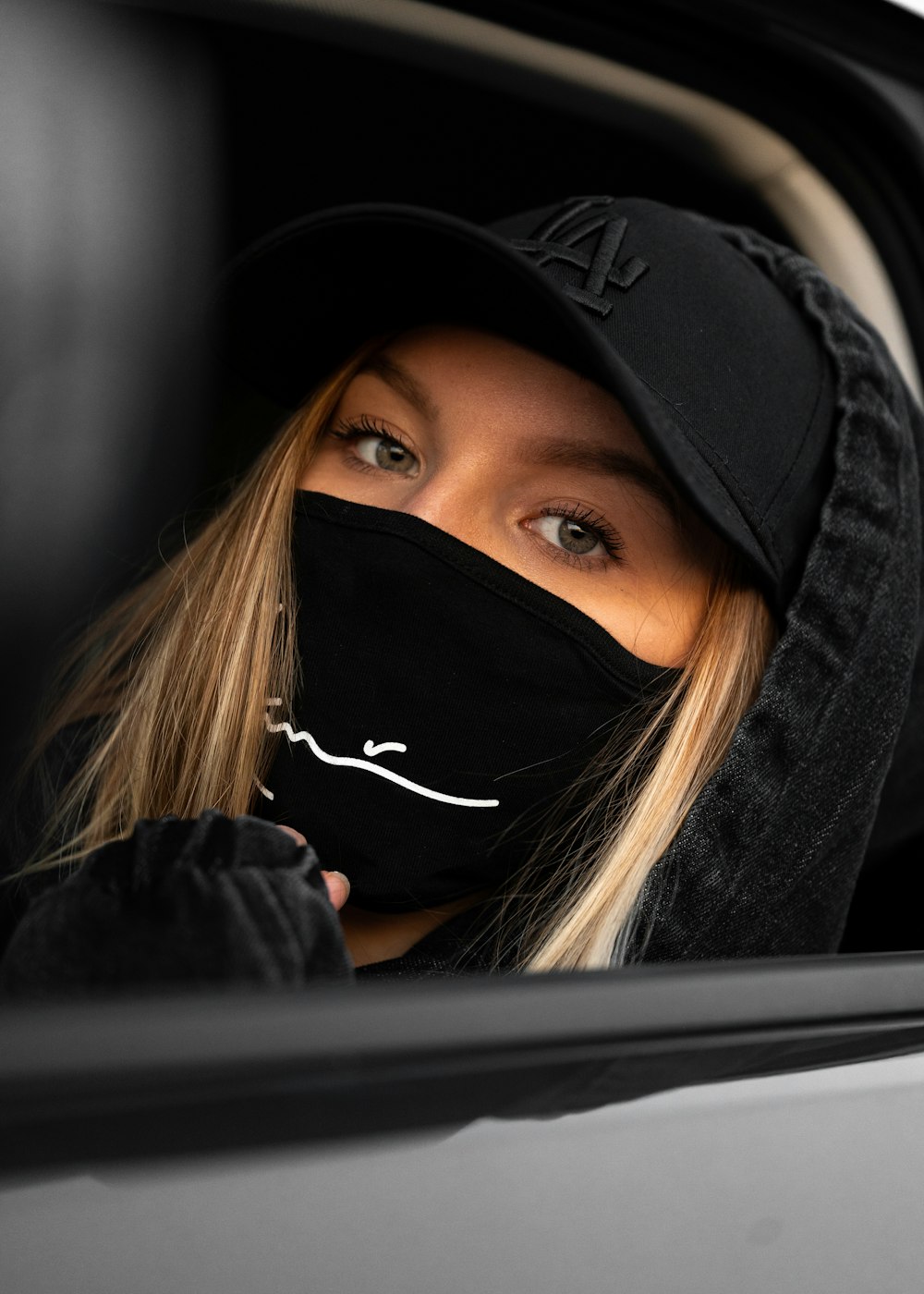 woman in black hoodie covering her face with her black hijab