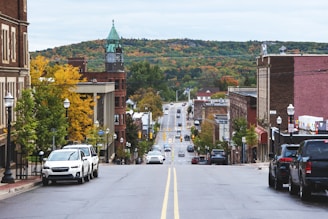 cars parked on side of the road near buildings during daytime