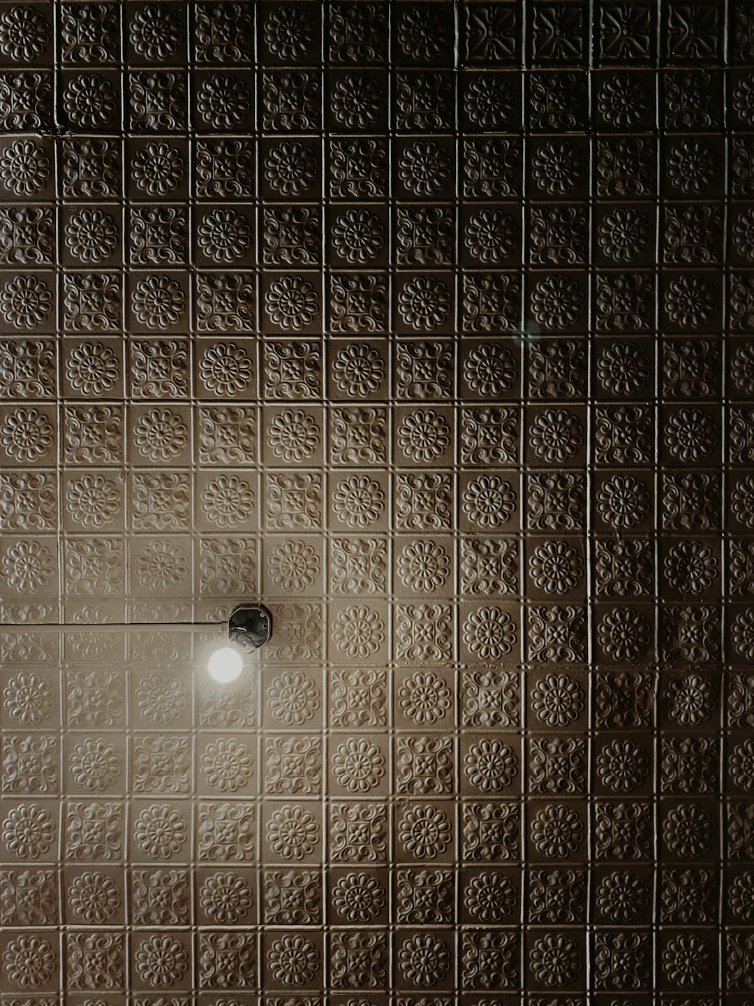 white light bulb on brown and beige wall