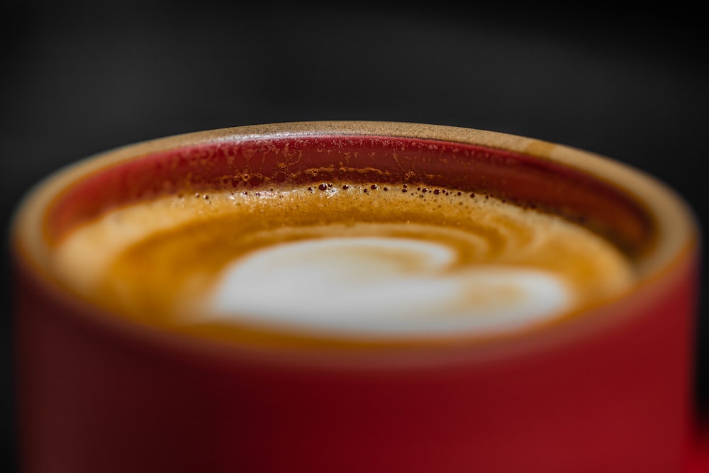 red ceramic mug with brown liquid