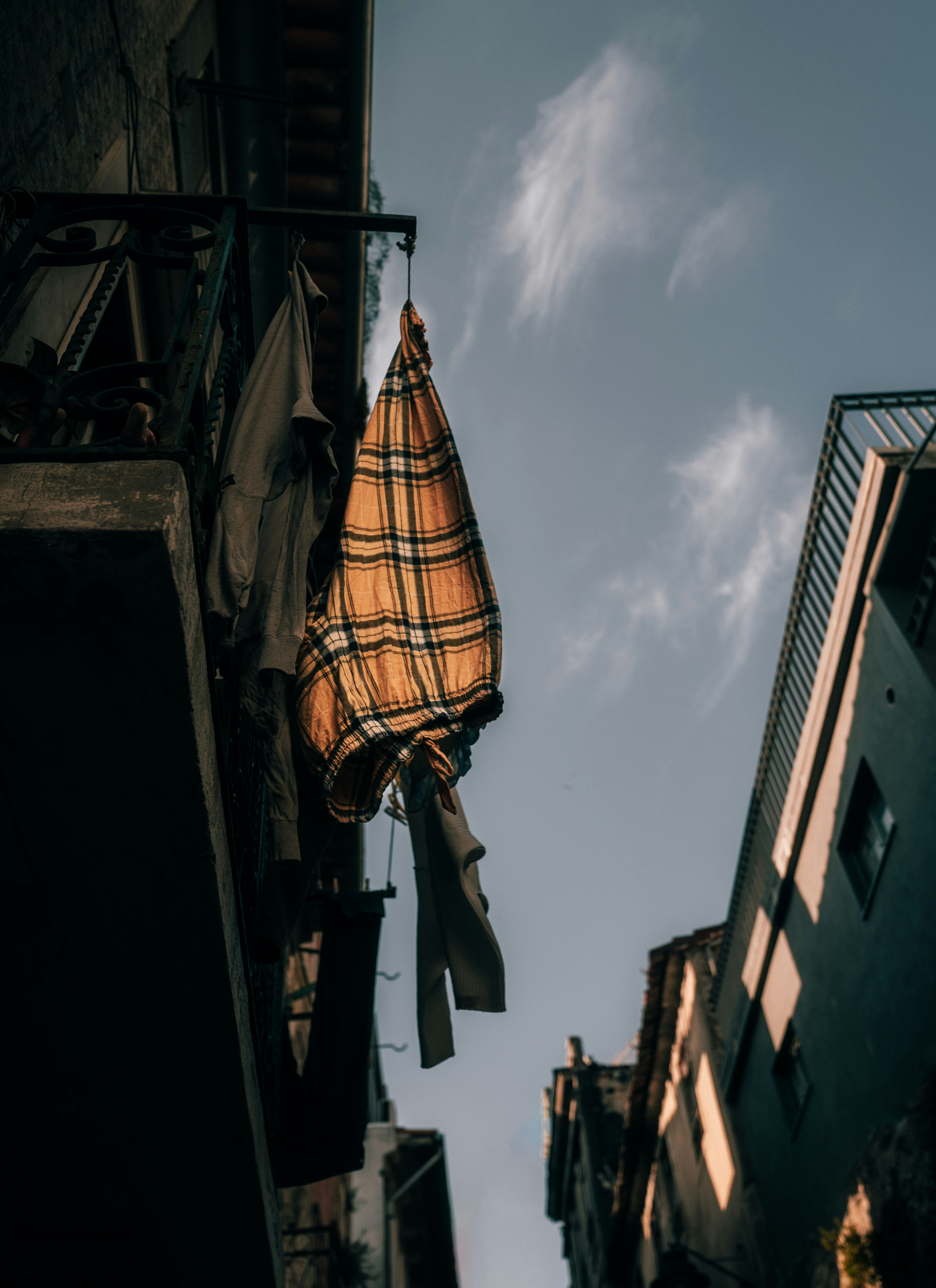 Yellow and black umbrella hanging on the building photo Free Porto