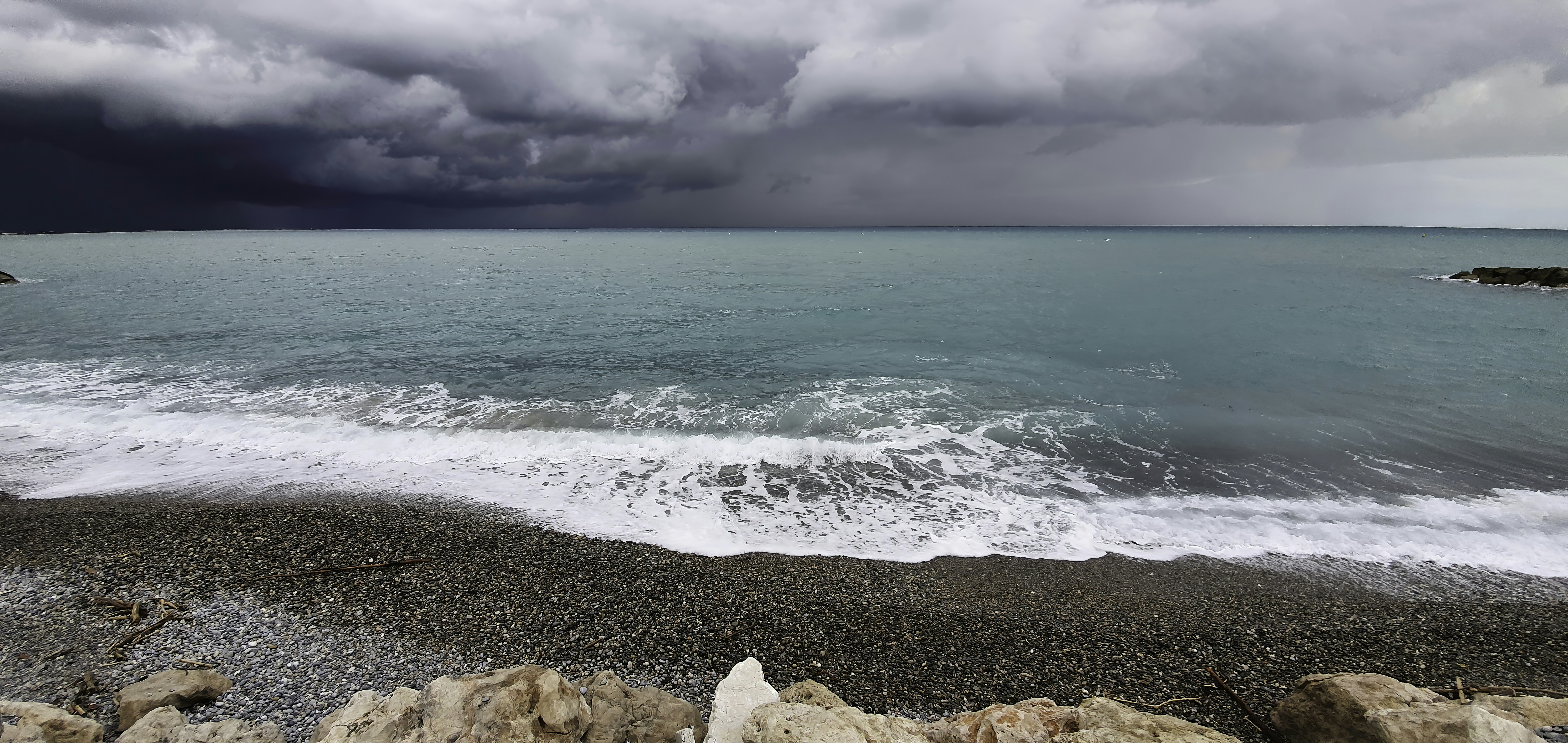 brown rocky shore under white clouds during daytime