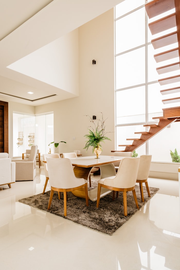 Double-height dining room with floating staircase and full-height glazing