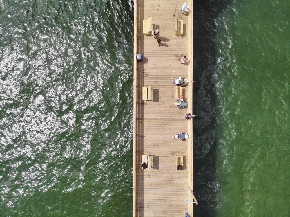 personnes sur un quai en bois brun pendant la journée