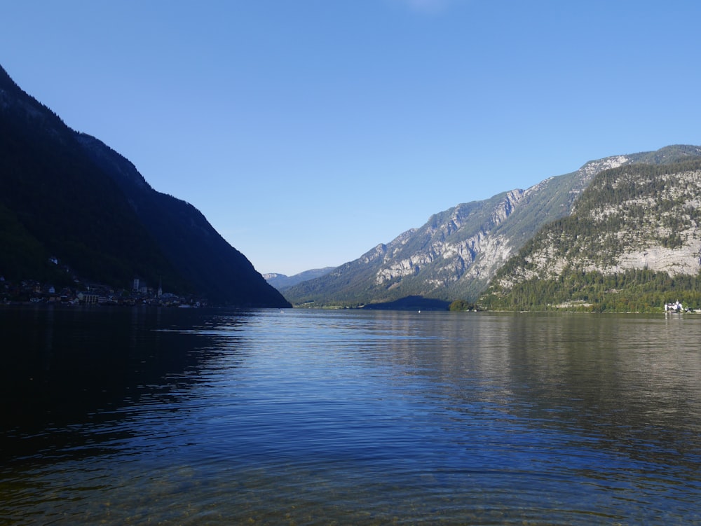 body of water near mountain during daytime