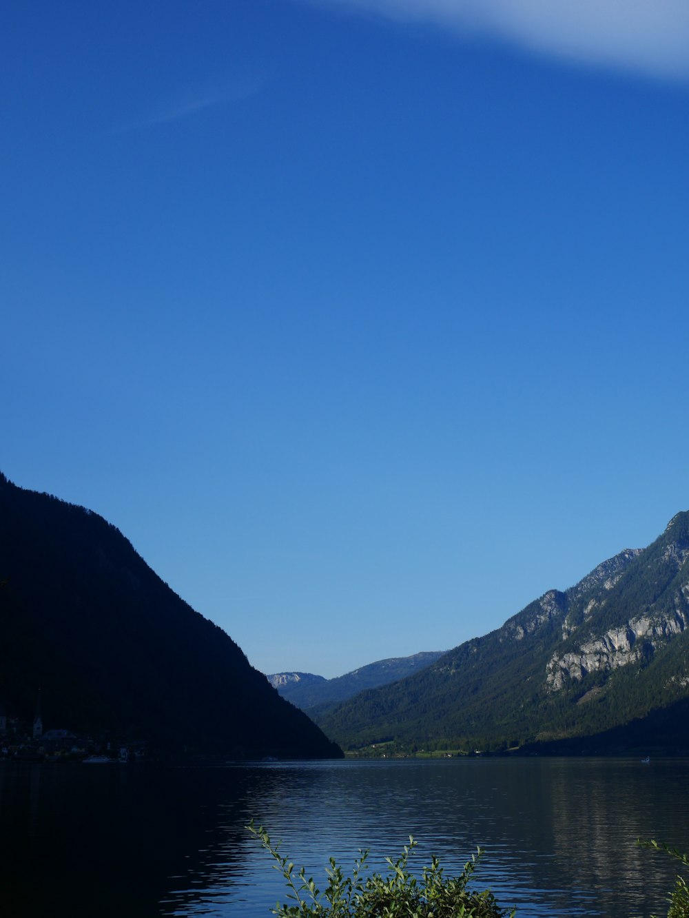 body of water near mountain during daytime