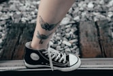 person wearing black converse all star high top sneakers