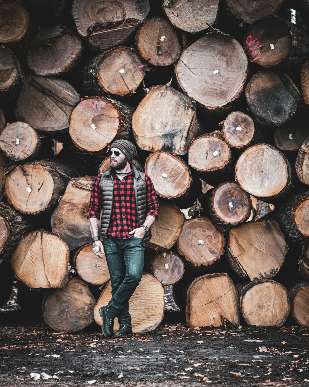 Person in blauen Jeans auf braunem Holzstamm stehend