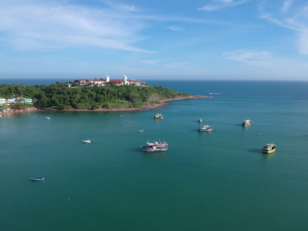 white boat on sea near green mountain under blue sky during daytime