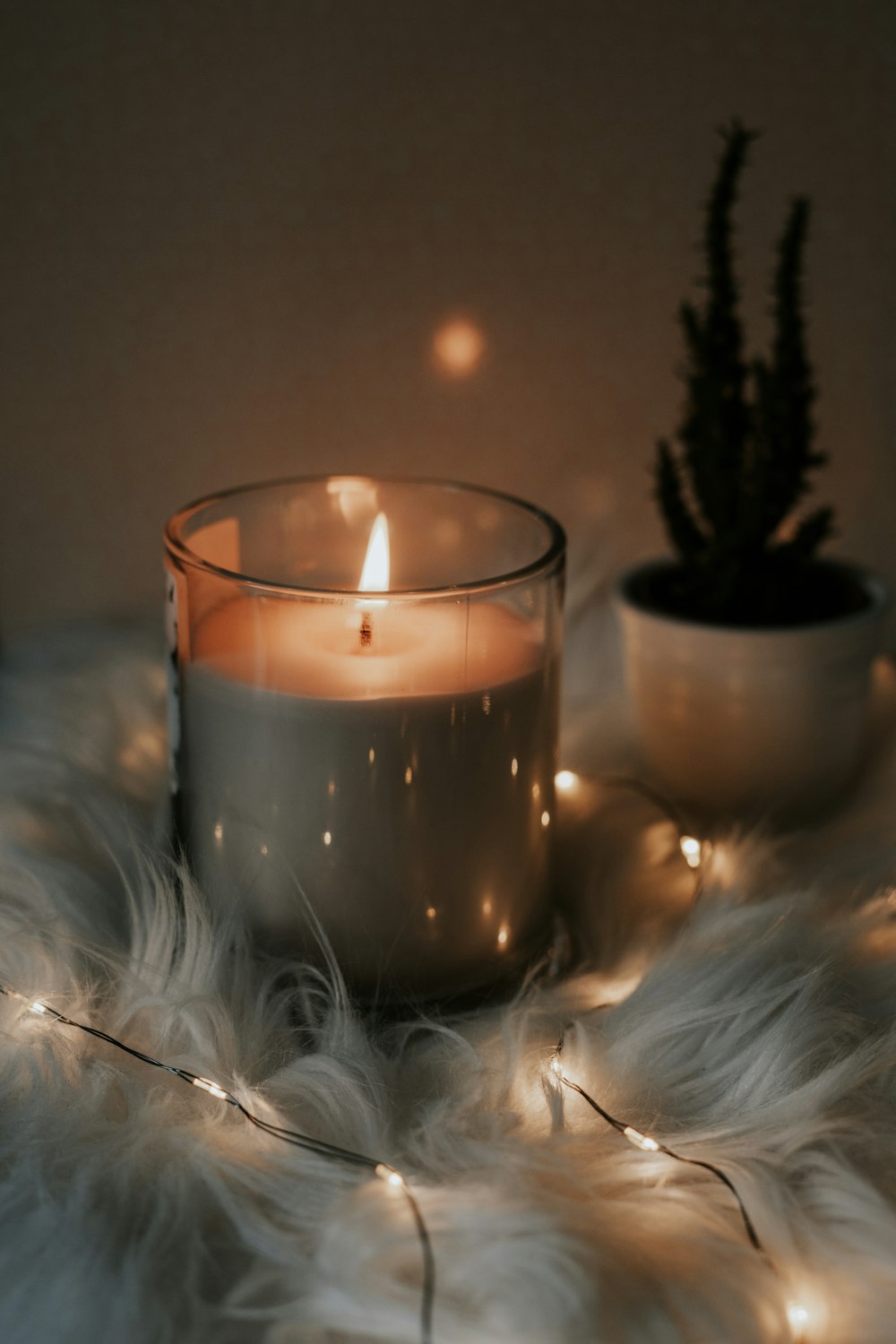 white candle on clear glass holder