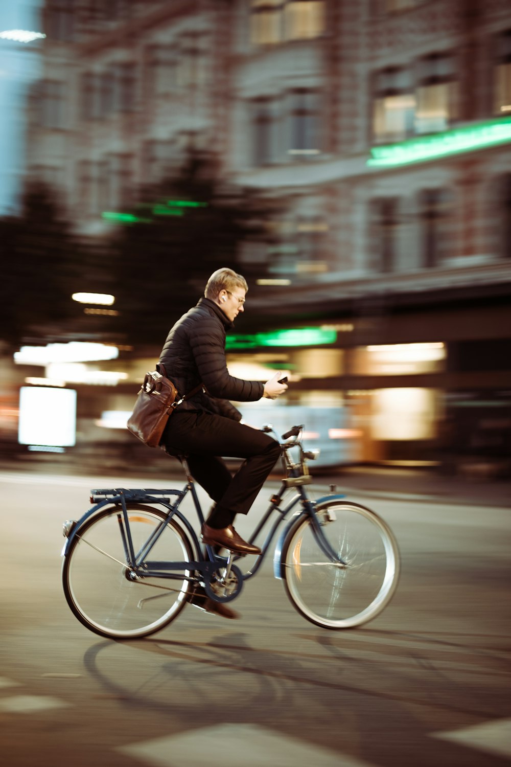 Mann in schwarzer Jacke fährt tagsüber Fahrrad