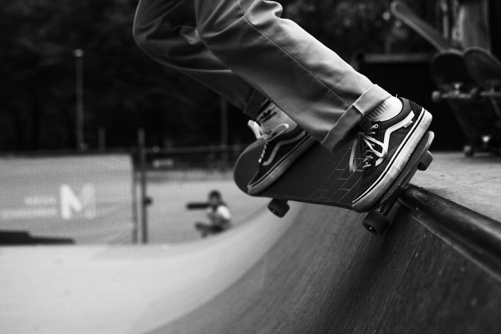 grayscale photo of person wearing black and white nike sneakers