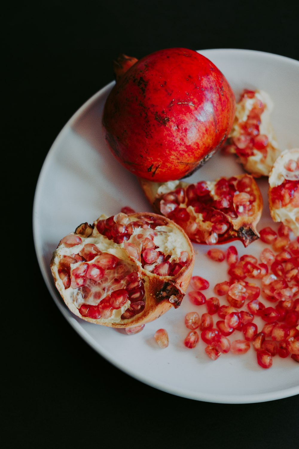 sliced pomegranate fruit on white ceramic plate
