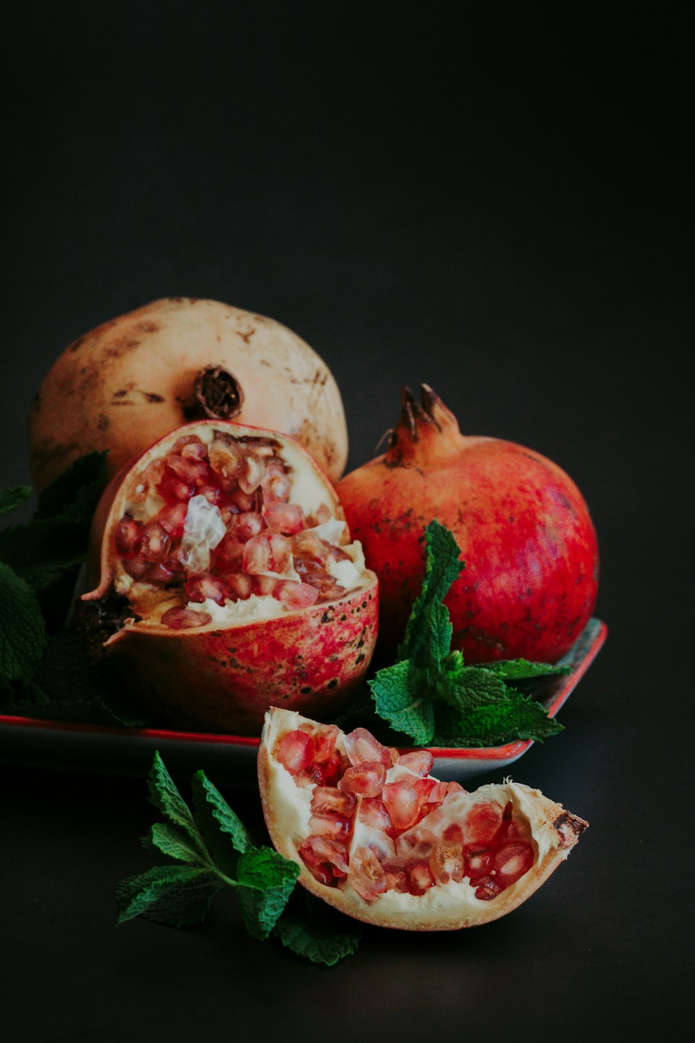 sliced pomegranate fruit on black surface